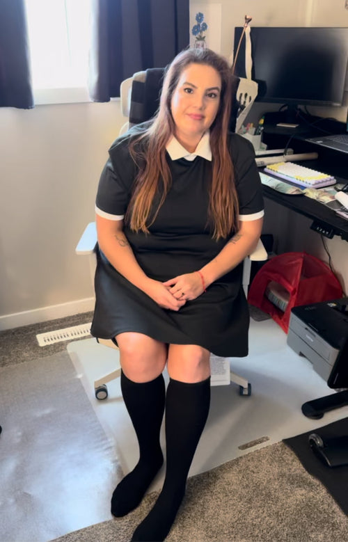 A woman working at an office desk wearing black knee-high compression socks